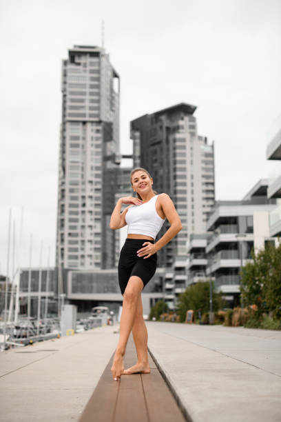 istock Seaside charisma. Athletic girl pier pose with elegance. 2053180604