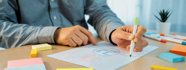 istock Skilled businessman brainstorms marketing ideas using mind maps.Variegated. 2053190658