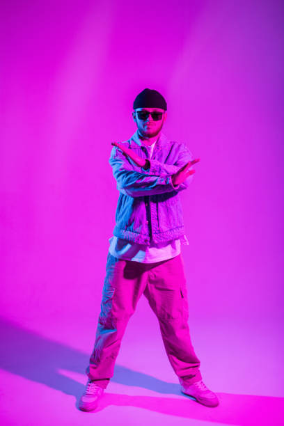 istock Handsome professional dancer man in trendy fashion denim clothes dancing in a creative studio with pink and neon light 2053197826