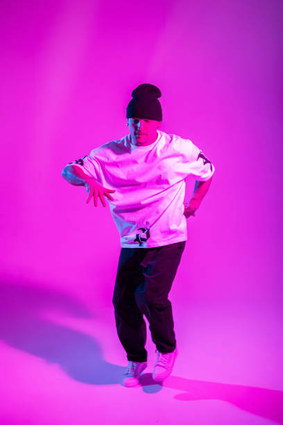 istock Professional dancer man dances in motion in a creative studio with pink and neon lights. Break Dance 2053206978