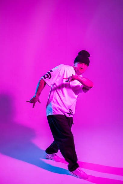 istock Handsome young professional dancer dancing in motion in creative studio with neon and pink light 2053209606