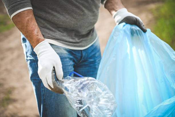 male volunteer collecting garbage in the forest