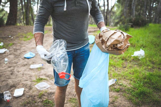istock male volunteer collecting garbage in the forest 2053232636