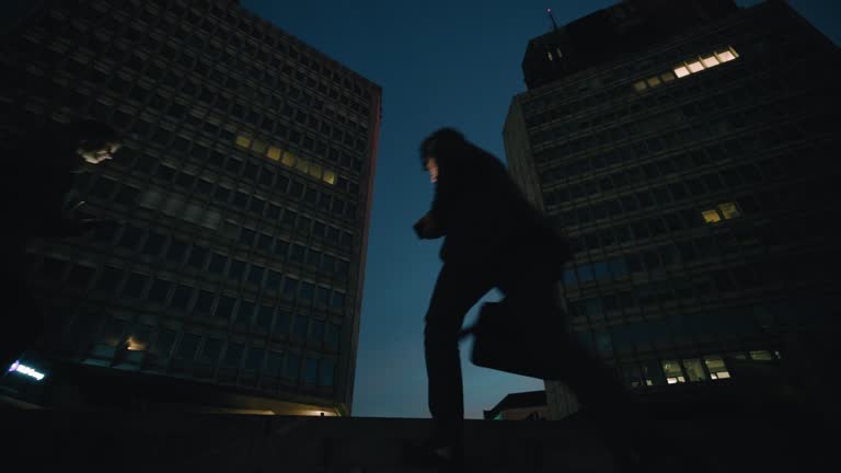 SLO MO Business People Climbing Steps Below Highrise Buildings At Night. Working Late.