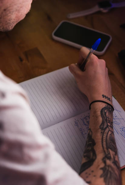 istock Hands of a creative editor jotting down ideas in his notebook on the desk 2053254285