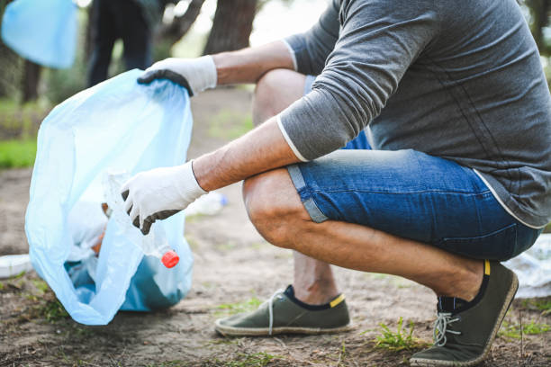 istock male volunteer collecting garbage in the forest 2053255312