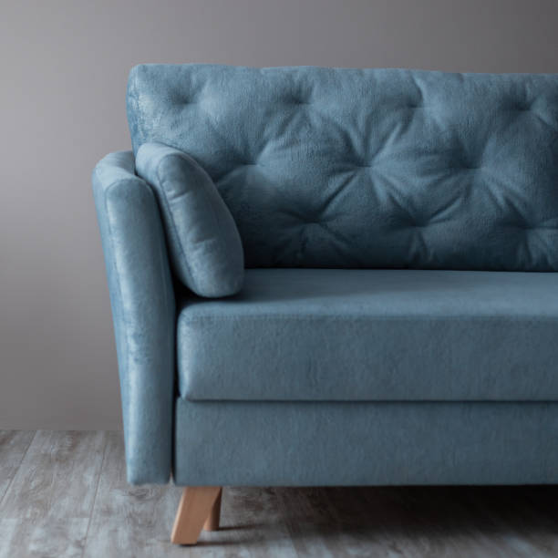 istock Comfortable blue vintage textile sofa against the background of a beige wall. Room interior 2053263241