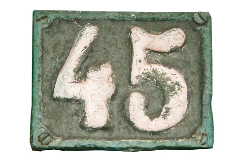 Old retro weathered cast iron plate with number 45 closeup isolated on white background