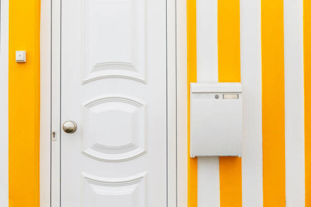 Beautiful creative house with yellow and white stripes with doors and mailbox. Delivery and letters, concept. Letter delivery to the door.