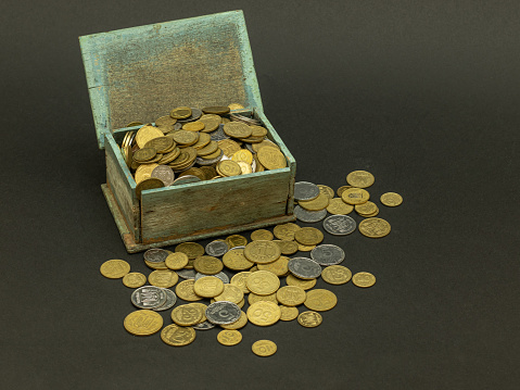Swiss coins and francs are in an open box against a blue background. Business concept. Web banner.