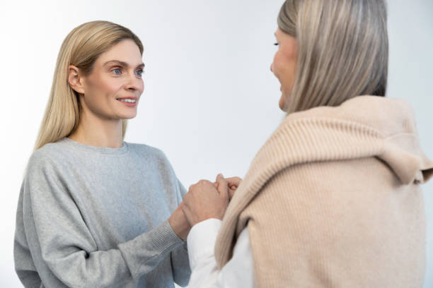 istock Mother and daughter standing close and holding hands 2053359373