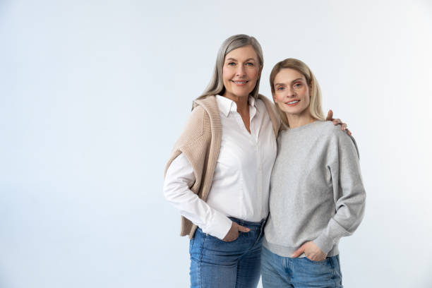 istock Mother and daughter standing together on a white background 2053359916