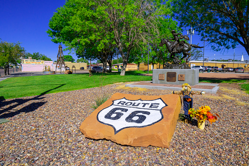 Holbrook, Arizona, United States - September 19, 2023:  Gillespie Park in Holbrook,  Arizona with the Route 66 sign and a bronze statue of a Hashknife Pont Express Rider carrying U.S. Mail