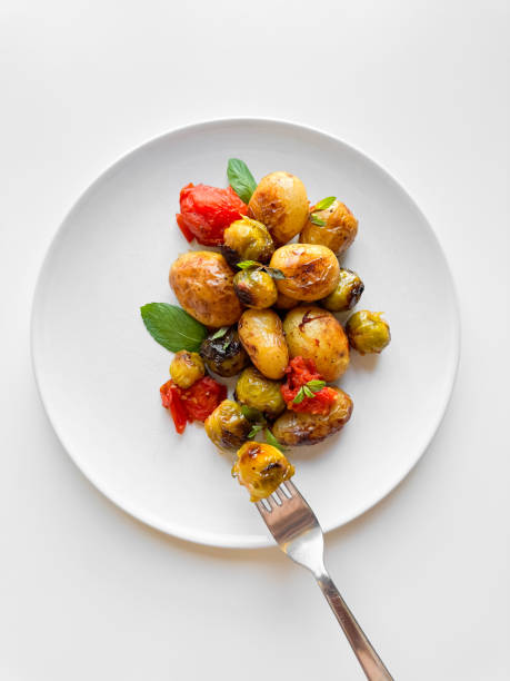 istock Roasted new potatoes and Brussels sprouts with cherry tomatoes and basil on white plate, healthy eating concept for weight loss. 2053408549