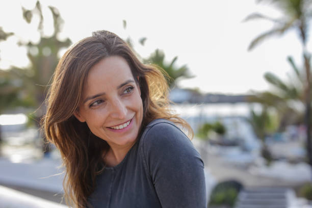 istock Young woman laughing while relaxing in city 2053424279