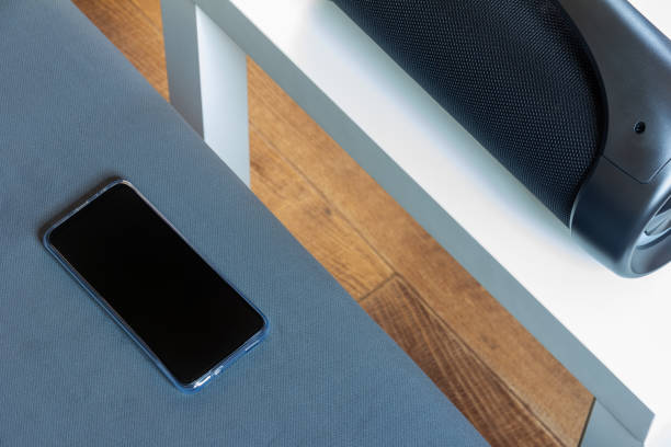 istock smartphone and black portable wireless speaker on the table 2053429550