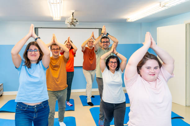 istock Disabled group of people practicing yoga together in a gym 2053431627