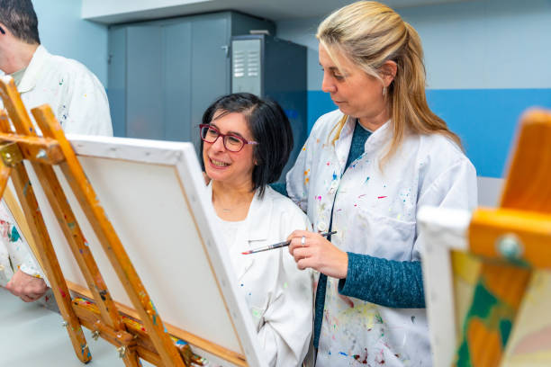 istock Teacher and woman with special needs in an art class 2053440480