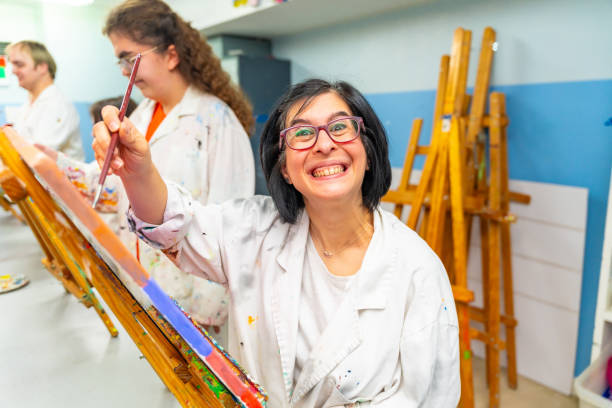 istock Disabled woman smiling at camera during a painting class 2053445166