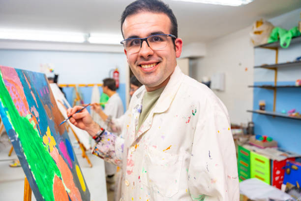 istock Disabled man happy while painting on canvas 2053448841
