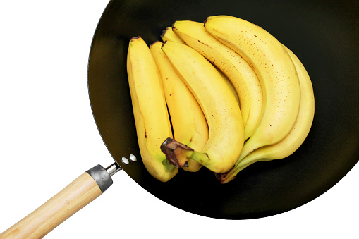 Over ripe brown banana in deep WOK isolated on white cutout.