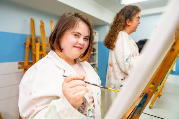 Woman with down syndrome in a painting class stock photo