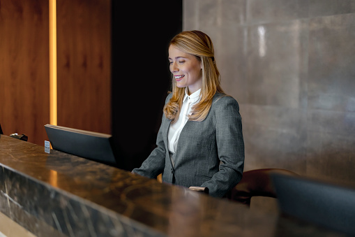 Female receptionist working at hotel counter