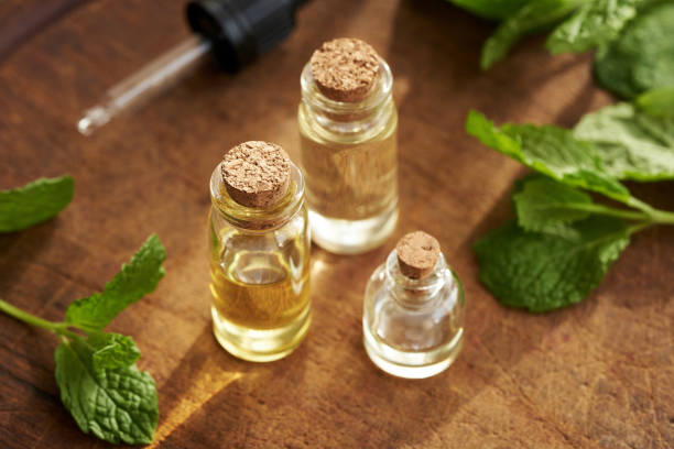 istock Three bottles of aromatherapy essential oil with fresh peppermint leaves 2053529422