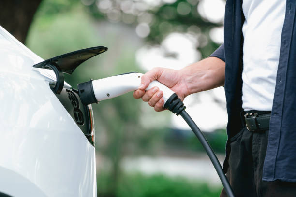 istock Man recharging battery for electric car during road trip. Exalt 2053531494