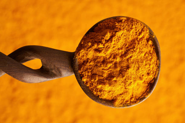 istock Turmeric powder on a wooden spoon, top view 2053536801