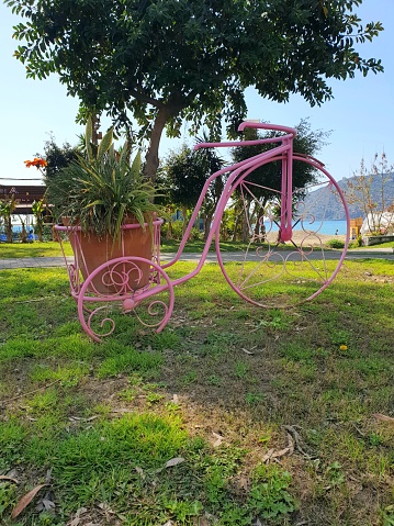 Municipal park garden decoration landscaping.  Colorful metwl bicycles on the grass by the beach.