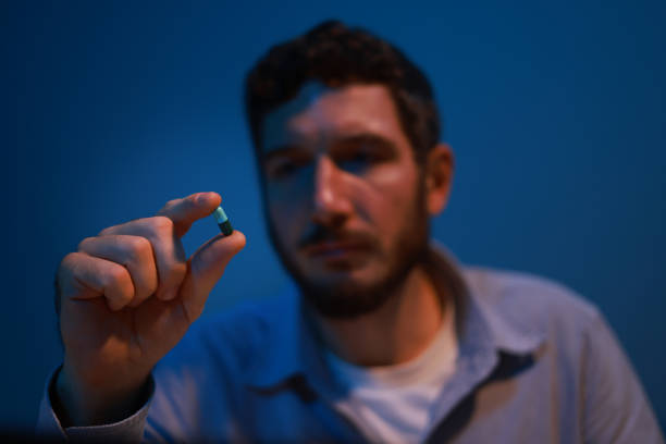 A young businessman takes capsule pills after sick from overwork at night