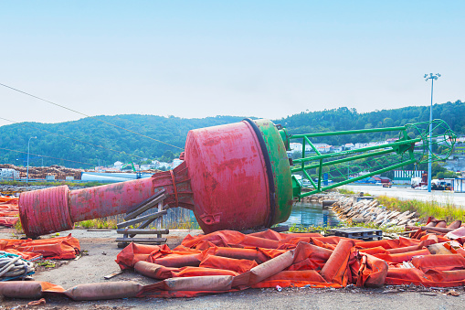 Large marine navigation buoy lies on the pier on the territory of the seaport.