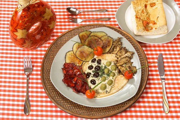 istock Fish fillet with eggplant slices, olives and cherry tomatoes on restaurant table 2053565056