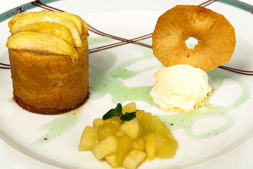 Apple dessert in syrup with ice cream and sweet bread in mint sauce