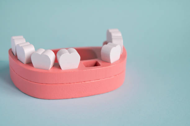 Toy wooden teeth and mouth on a turquoise background. stock photo