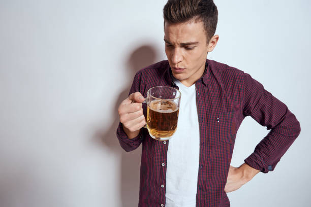istock Cheerful man with mug of beer alcohol emotions light background 2053611810