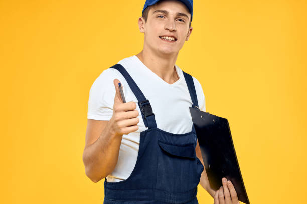 istock Man in working uniform documents rendering of services delivery service yellow background 2053649054