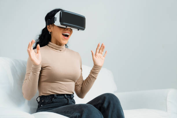 istock Young woman using virtual reality VR goggle at home for crucial experience 2053681957