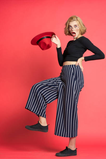 istock Beautiful blonde red hat in hands studio luxury pink background 2053732321