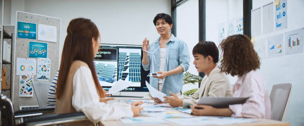 asian business people team brainstorm meeting in sustainable corporate office. presentation esg project planning, solar panel, wind turbine power energy generation. environmental conservation concept - animation - fotografias e filmes do acervo