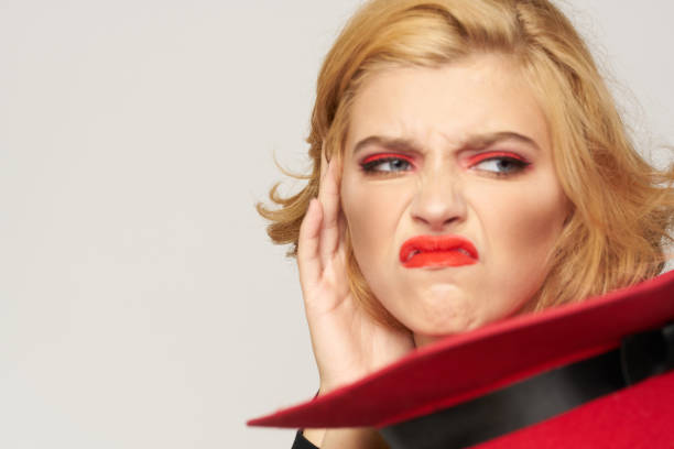 istock Cute blonde short haired red hat in hand close-up light background 2053744506