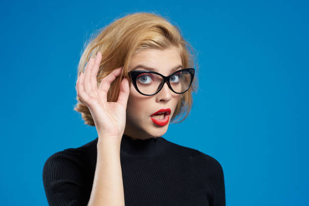 istock Blonde with short hair red lips glasses black jacket blue isolated background 2053750729