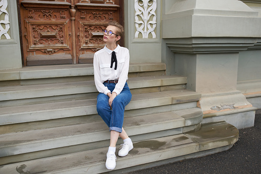 student with glasses walking around the city with a book communication. High quality photo