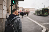 Rear view of a tourist man with backpack on a city street.