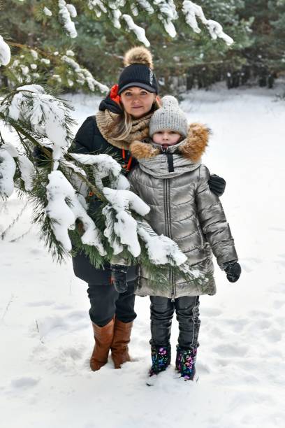 istock Two families walk in a winter snowy forest. 2053815141