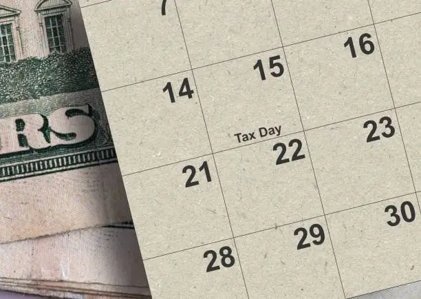 Photo of Calendar showing Tax Day for 2024 with money in background