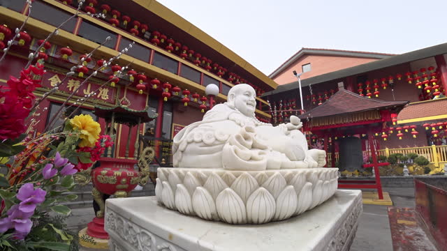 Tracking in Beautiful Chinese temple exterior with a white Happy Buddha Statue