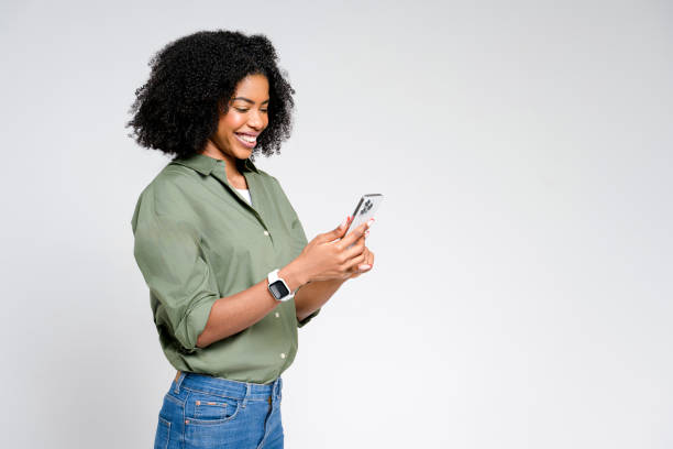 African-American woman exudes casual elegance as she reads content on her smartphone