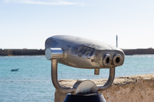 Tourist binoculars at the viewpoint of Santa Catalina Castle in Cadiz, overlooking the sea.